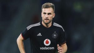 A promotional graphic featuring football player Andre de Jong holding up a black Orlando Pirates jersey, with the club's skull and crossbones crest and gold stars in the corner.